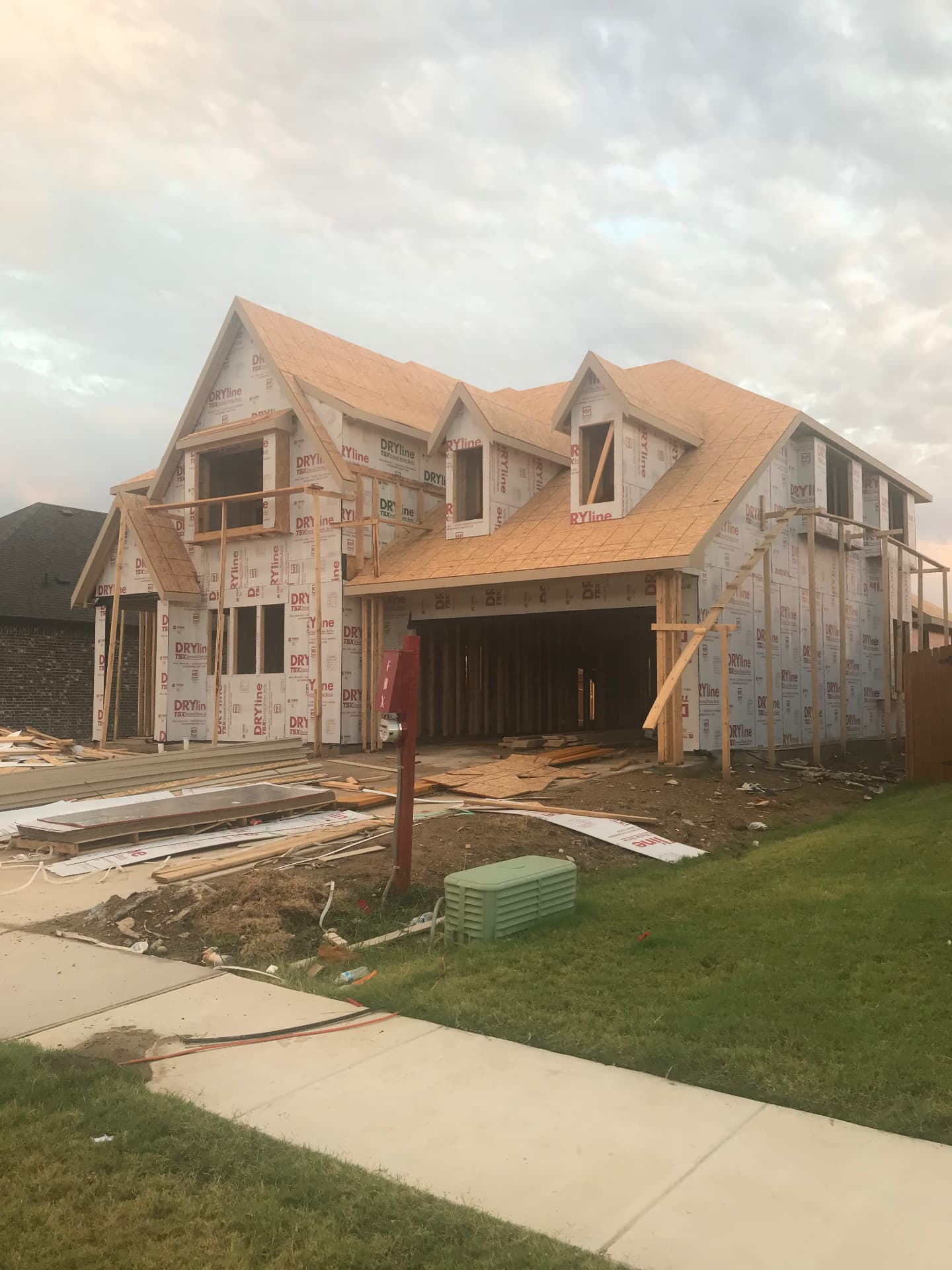 Roof decking and weather barrier installed — the home is dried in.