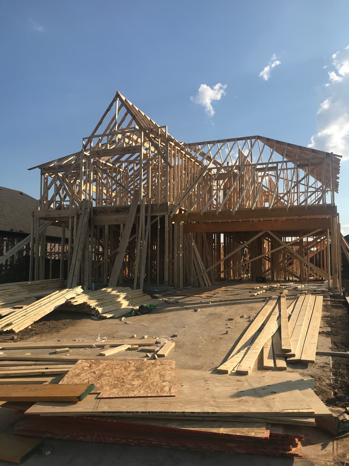 Two-story framing and roof trusses going up over the finished slab.