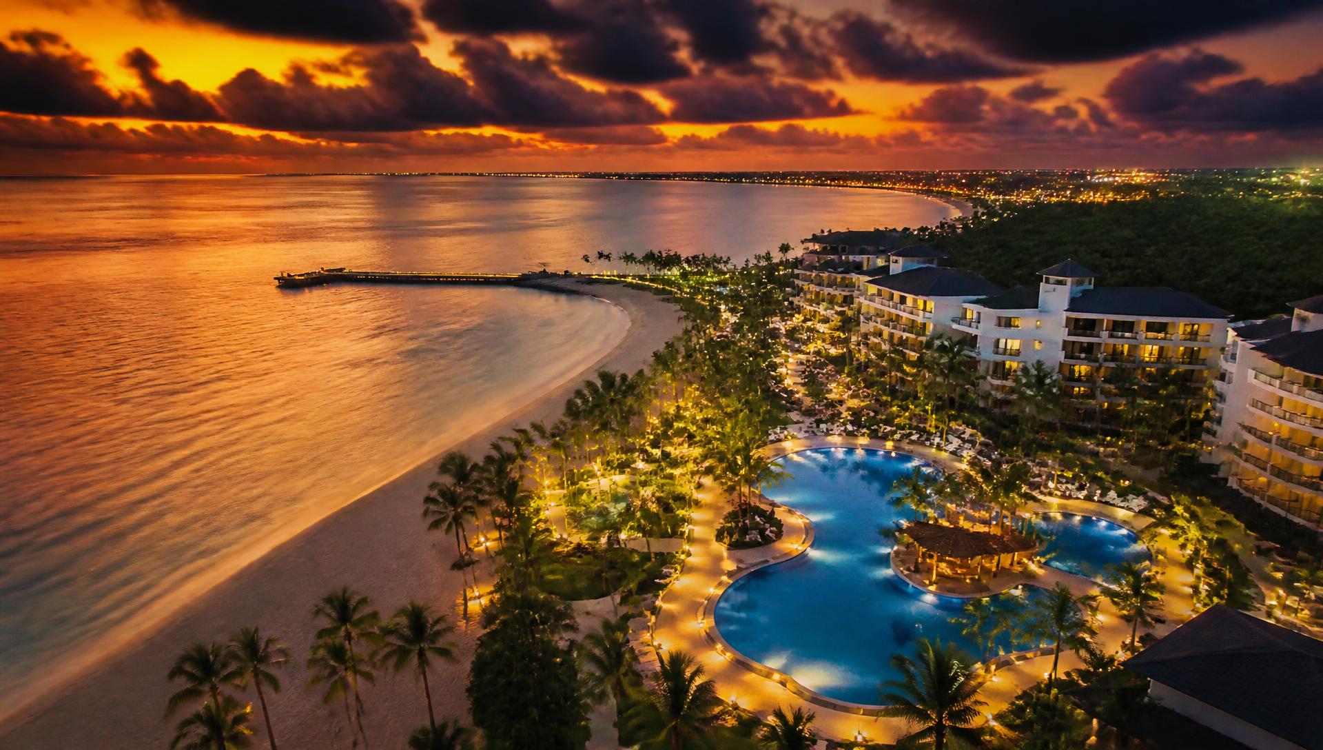 Aerial view of a coastal resort and hospitality development at dusk